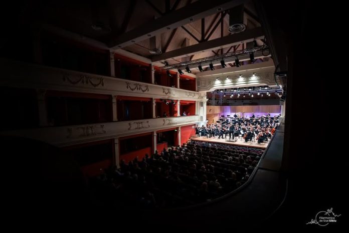 Concert la Filarmonica Sibiu cu orchestra simfonică pe scenă sub lumina reflectoarelor
