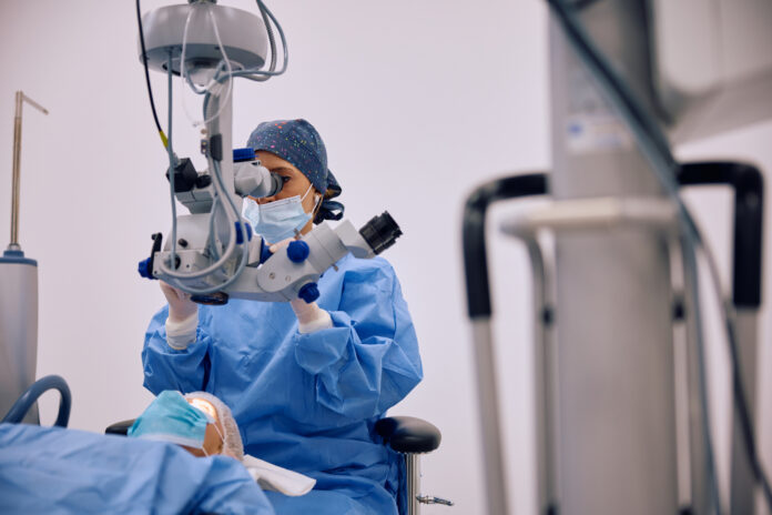 Medic specialist efectuează operația de cataractă cu echipament de precizie într-un bloc operator modern