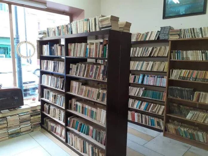 Interiorul anticariatului social „Cărți fără preț” din Sibiu, cu rafturi pline de cărți vechi.