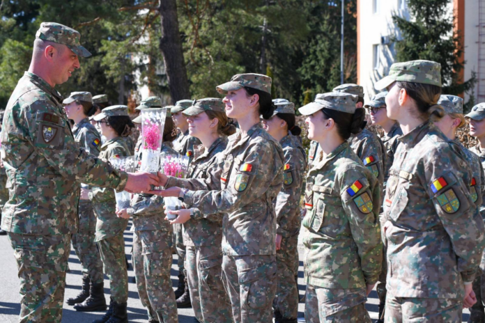 Femei cadet în timpul unei exerciții militare de teren, demonstrând tăria