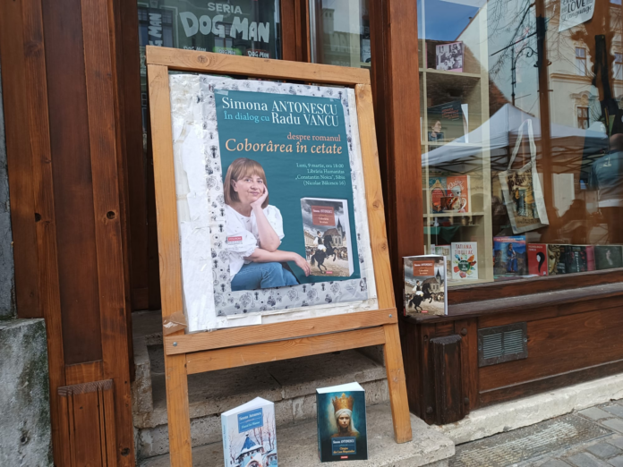 Publicul care ascultă prezentarea romanului istoric în cadrul lansării de carte