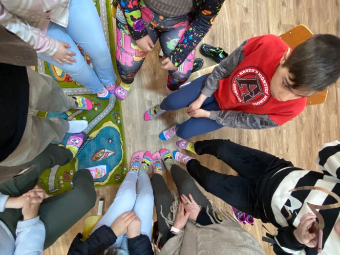 Elevi de la CSEI Turnu Roșu pozează zâmbind, unii cu șosete diferite, în semn de solidaritate