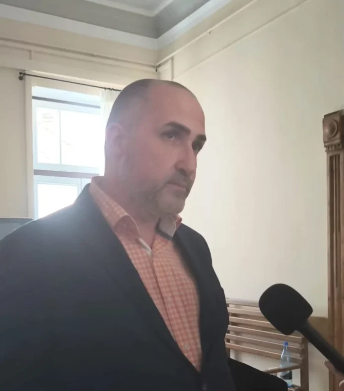 Avocat discutând despre probe video Kreiner, așezat la birou cu documente