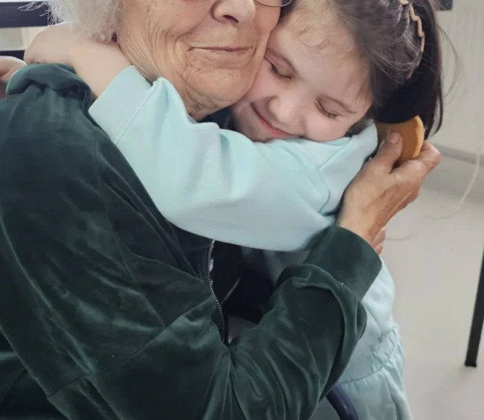 Grup de copii și bătrâni zâmbind împreună, creând momente de bucurie la UAMS Săliște.