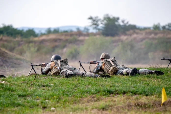 Poligonul de trageri Poplaca, peisaj cu tunuri și ținte pentru exerci tragerilor pentru luna aprilie în poligonul Poplaca afișat pe un ecran