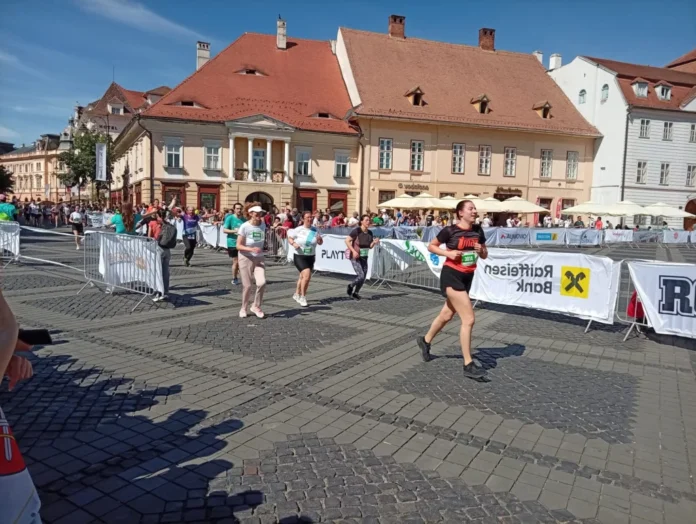 Grup de participanți la Maratonul Internațional Sibiu, zâmbind și pregătindu-se.