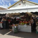 Clienți alegând mere și pere proaspete de la un producător din Piața Cibin
