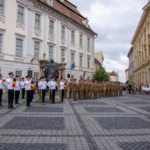 Ceremonie publică pentru Ziua Imnului Național în Piața Mare din Sibiu, cu participanți și steaguri