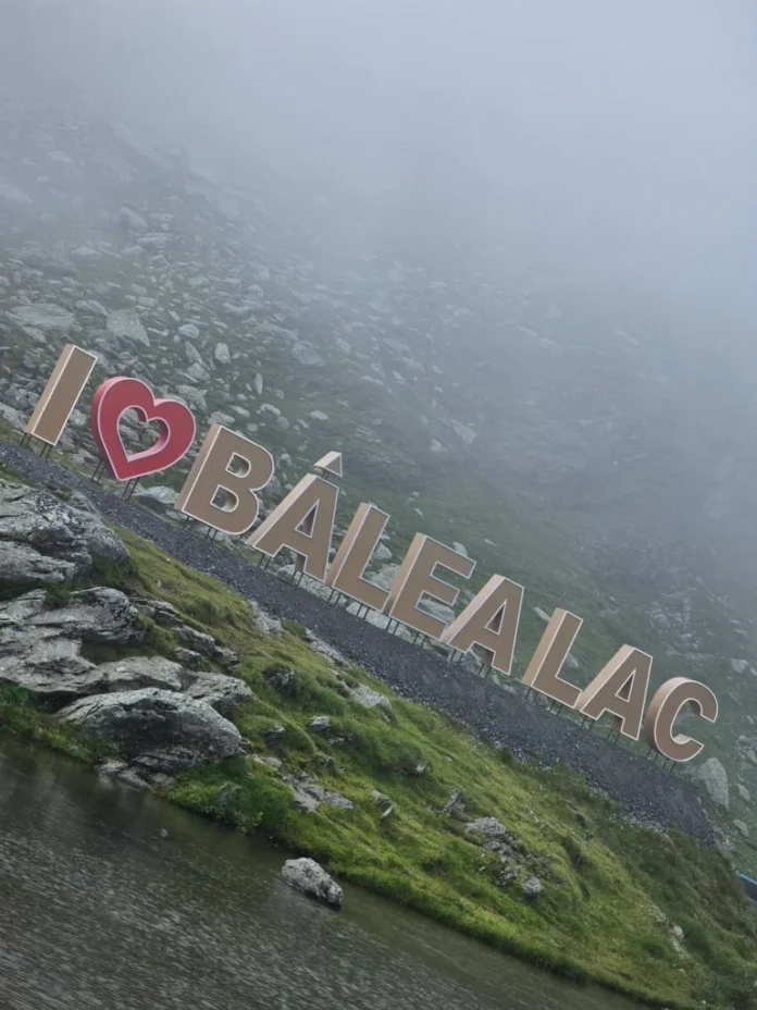 Litere mari roșii „I love Bâlea Lac” montate pe malul lacului, cu munții în fundal.