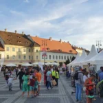 Târgul de Carte Gaudeamus în Piața Mare din Sibiu, cu standuri pline de cărți și vizitatori.