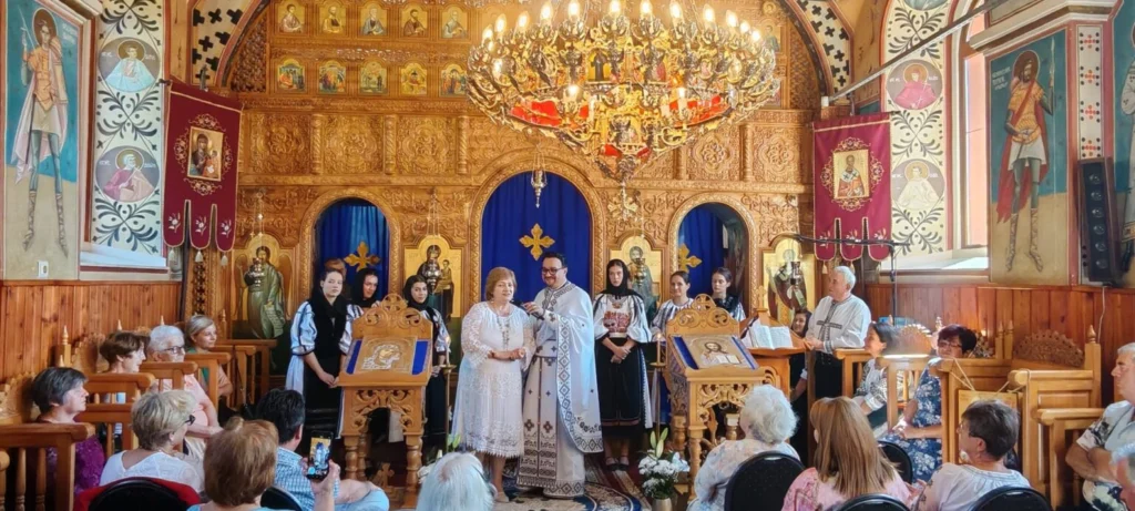 Profesorul Dumitru Acu omagiat în cadrul unui eveniment festiv la Hamba, înconjurat de participanți