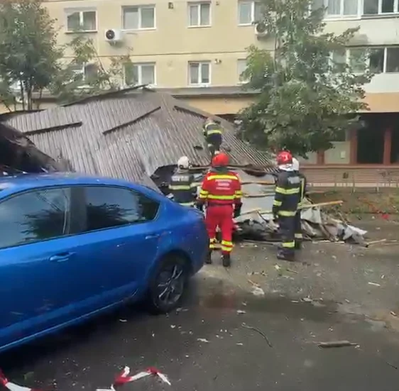 Acoperiș prăbușit în Sibiu, văzut de aproape, cu țigle și grinzi distruse pe mașinile lovite.