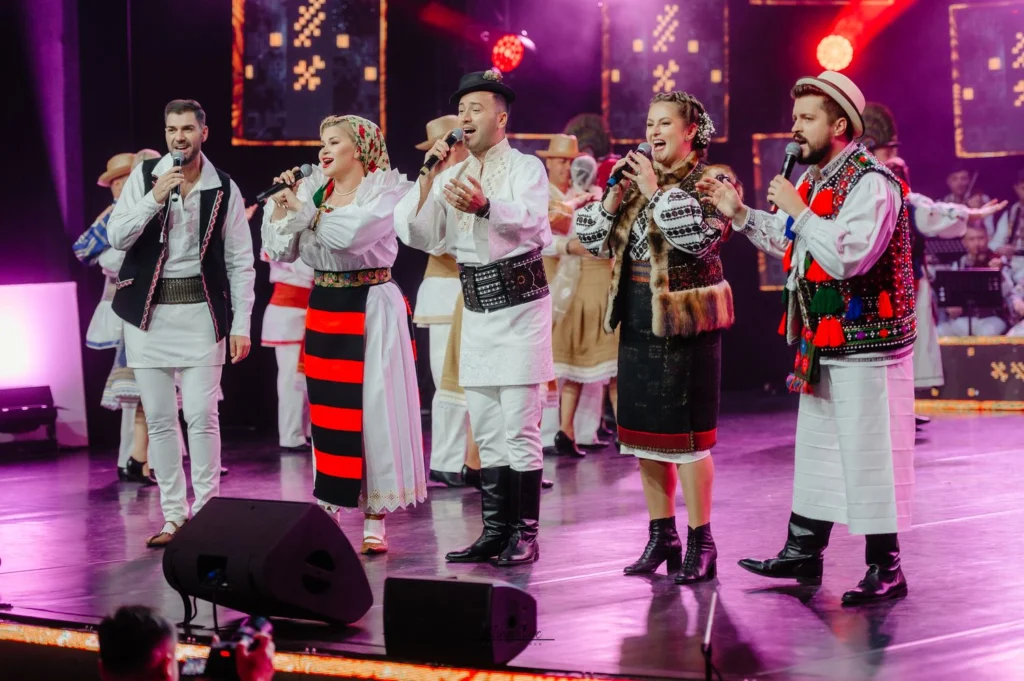 Publicul Festivalului Cântecele Munților aplaudă în Piața Mare din Sibiu, atmosferă festivă.