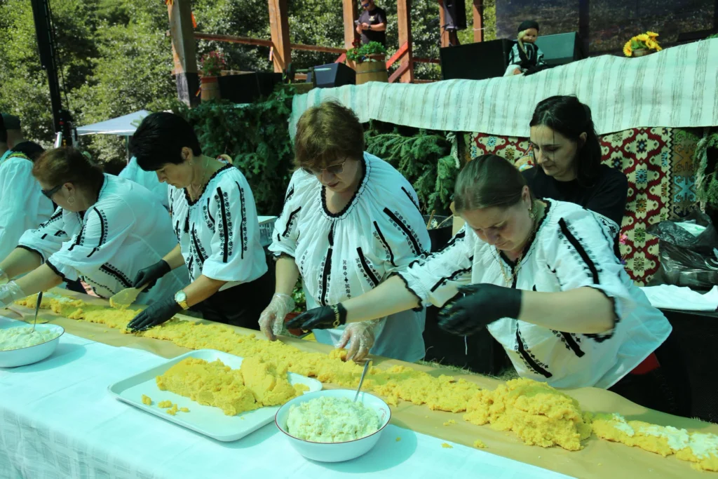 Participanți entuziaști gustând brânza tradițională la Festivalul Brânzei Rășinari