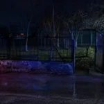 Gardul unei case din Orlat, iluminat parțial noaptea, în contextul unei posibile încălcări a proprietății private.