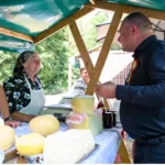 Dumitru Beschiu la Festivalul Brânzei și al Țuicii de la Rășinari, discutând cu producători locali.