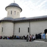 Mulțime de credincioși așteaptă în fața intrării principale a Mănăstirii Nocrich.
