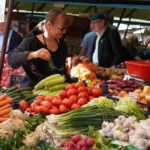 Oamenii cumpără fructe și legume proaspete de la tarabele colorate din piețele tradiționale din Sibiu.