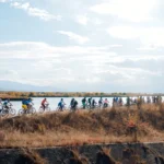 Grup de bicicliști în timpul Bike Tour Făgăraș, pedalând pe un drum pitoresc în Țara Oltului