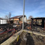 Clădire parțial prăbușită și fumegândă după incendiul de la Cârța, cu cadre de intervenție.
