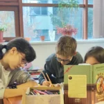 Copii la un club de lectură, așezați în cerc și ascultând o poveste.